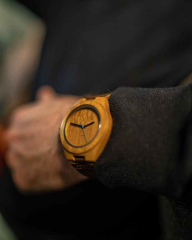 selective focus photography of person wearing round brown analog watch